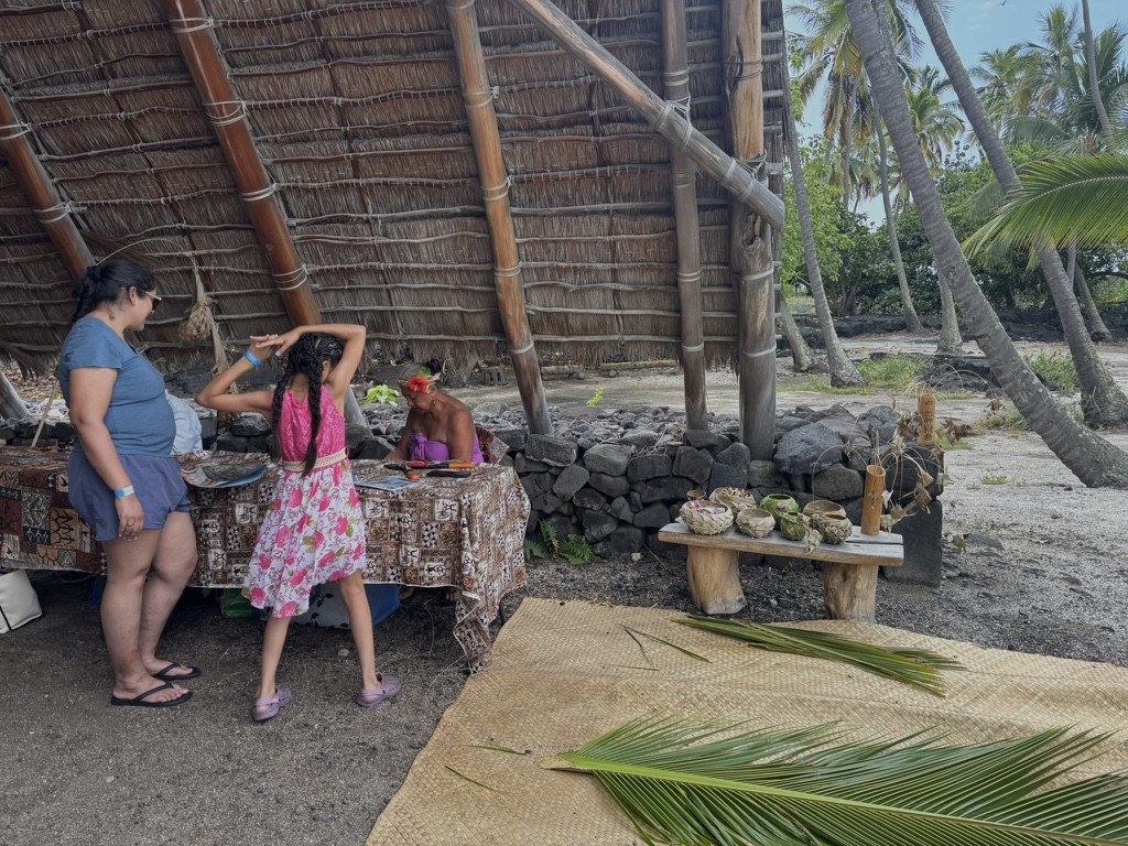 Cultural craft demonstration under a thatched hut
